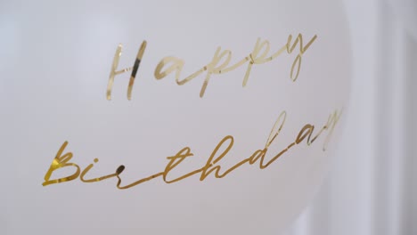 globos blancos con inscripción dorada feliz cumpleaños