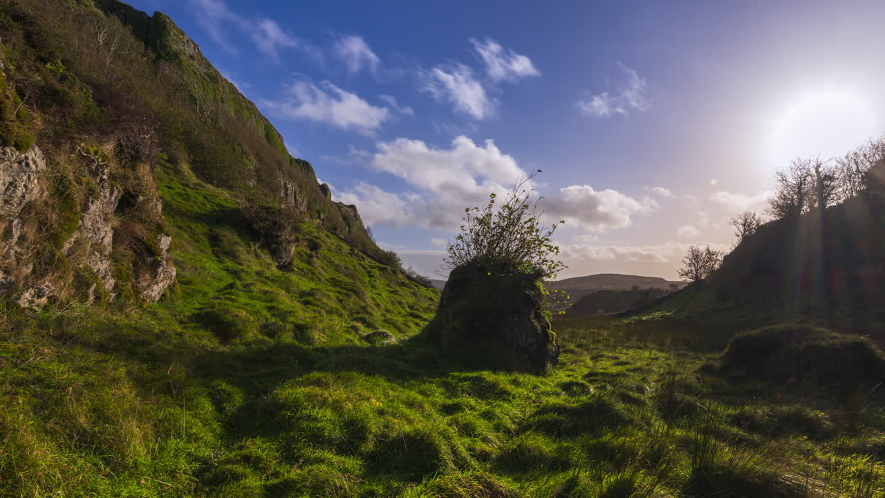 timelapse de la naturaleza rural pastizales con una sola roca en un valle con la puesta de sol detrás de la colina visto desde carrowkeel en el condado de sligo en irlanda