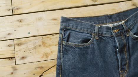 Primer-Plano-De-Jeans-Sobre-Fondo-De-Madera-Con-Espacio-De-Copia