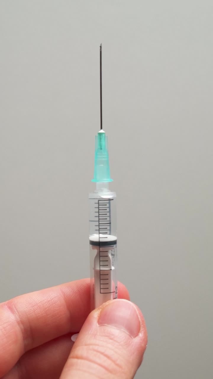 Man removing air bubbles from a syringe. Medical. Vaccination. Close up