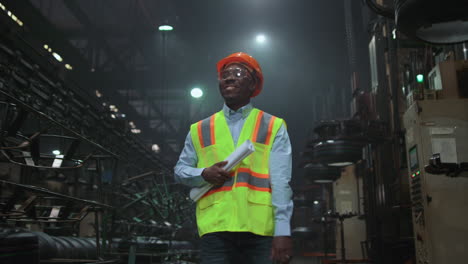 Black-hair-supervisor-walking-tyre-warehouse-wearing-modern-safety-uniform.