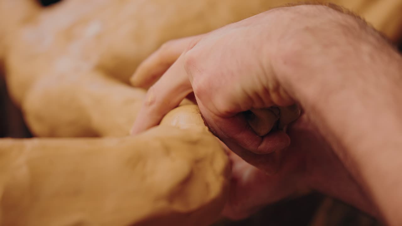 close up of finger pressing soft clay with precision and natural light