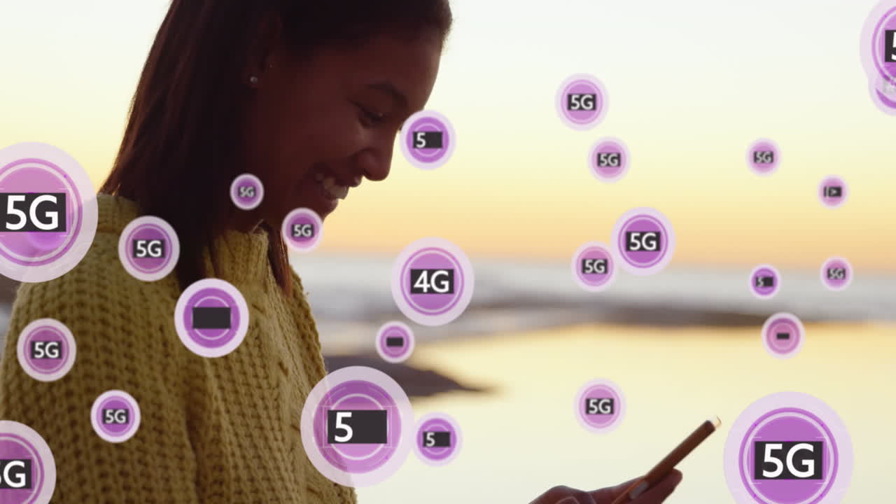 animación de pancartas de texto púrpura de 5g sobre una mujer afroamericana usando un teléfono inteligente cerca del mar.
