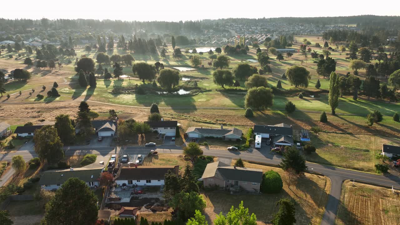 해가 뜰 때 골프 코스를 둘러싼 집들의 넓은 조감도