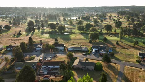 wide aerial view of homes surrounding a golf course at sunrise