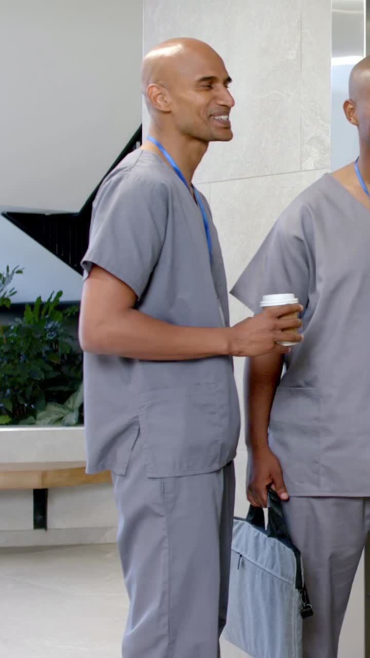 Video verticale: Uomo in camice grigio con una tazza che cammina dopo una chiacchierata, entra nell'ascensore dell'ospedale, con un cordino