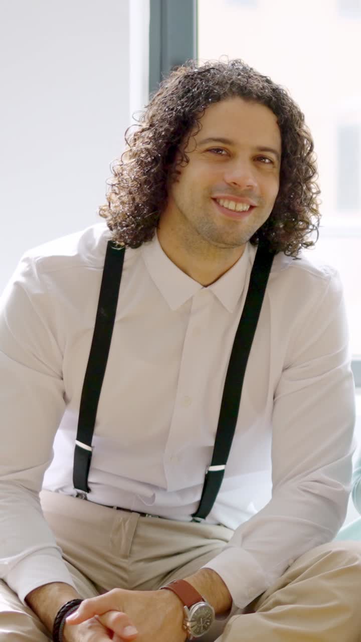 Latin man smiling at the camera sitting relaxed on coworking