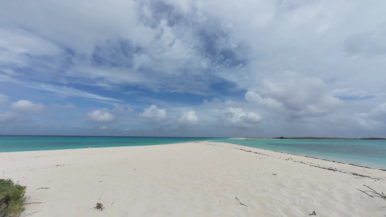 Timelapse della incontaminata lingua di sabbia bianca a Cayo de Agua a Los Roques, Venezuela, con acque caraibiche turchesi e nuvole tropicali in rapido movimento.