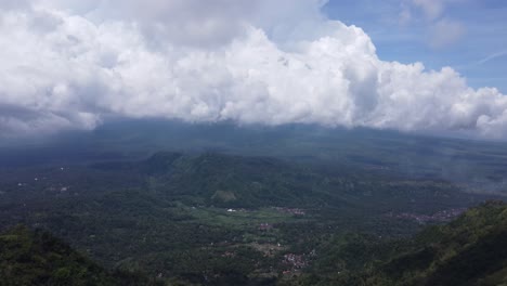 White-puffy-clouds-over-a-green-tropical-valley-of-balinese-villages-amid-forests-and-mountains-near-lahangan-sweet,-Bali