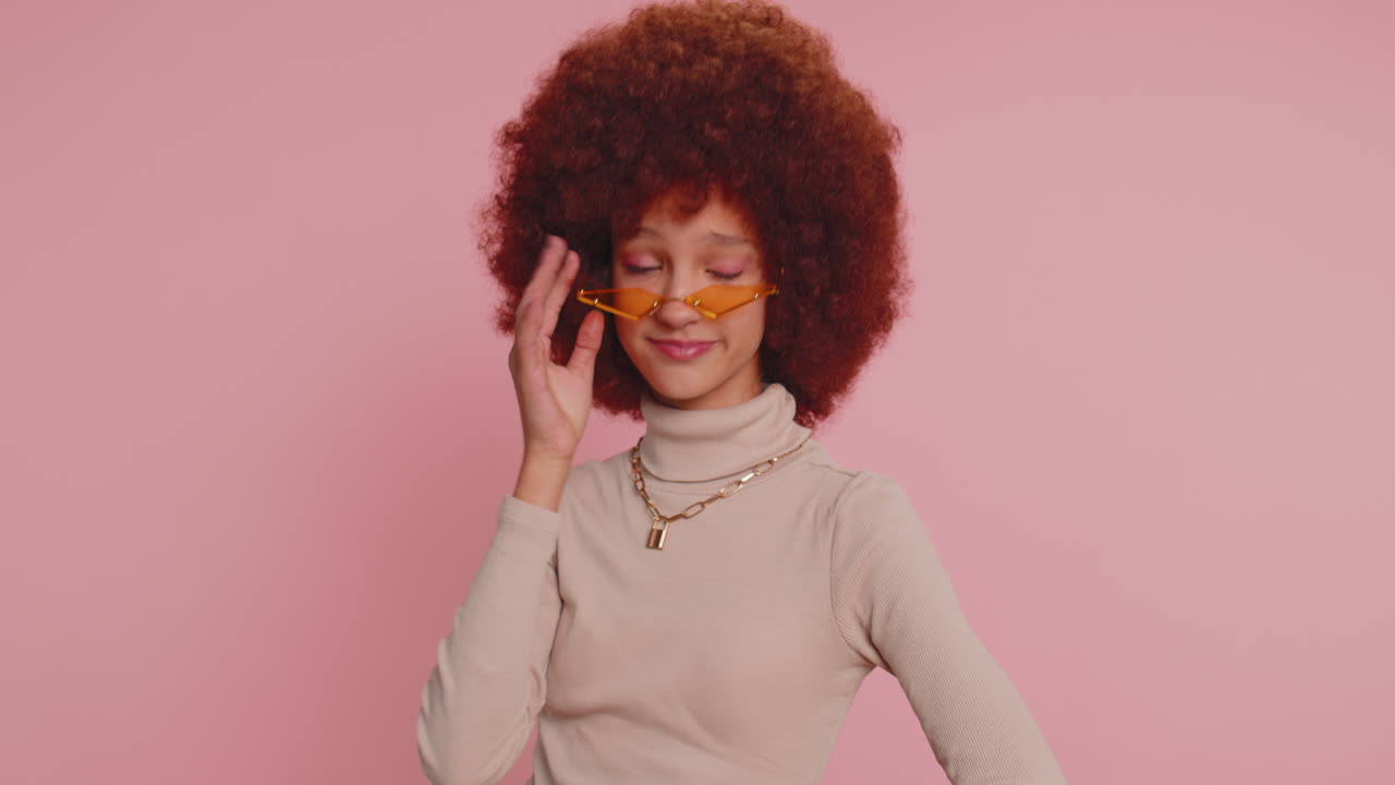 유쾌하고 사랑스러운 젊은 십대 아이 소녀 아이 미소, 스튜디오 분홍색 배경에 카메라를보고