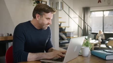 handsome man rolling up his shirt sleeves and start typing on computer