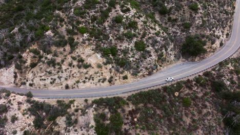 following a white vehicle as it takes a joyride on the angeles crest highway in the san gabriel mountains - aerial