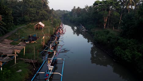 dawn's embrace: witness the tranquil ballet of fishing boats on bali's river at sunrise, where tradition and nature unite in harmonious splendor