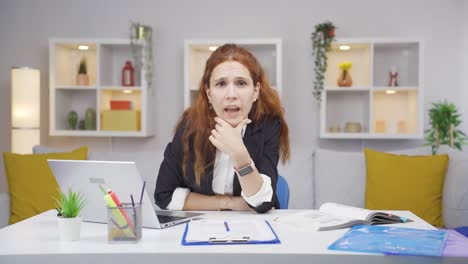 una trabajadora de oficina en casa recibe malas noticias de la cámara.