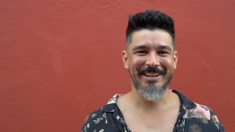 Smiling-bearded-man-against-bright-wall