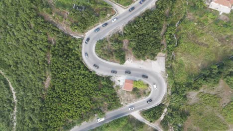 aerial ascend over albanian mountain serpentine road with intensive traffic