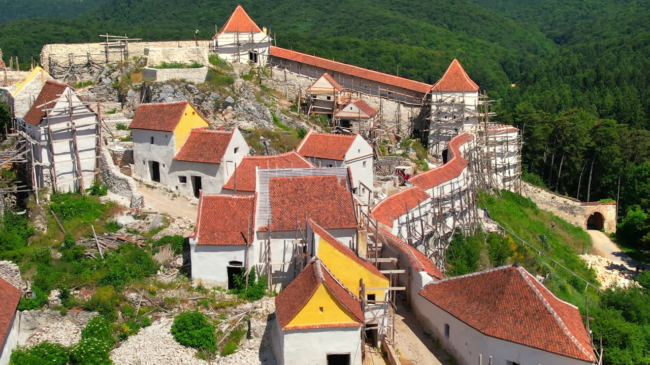 Letecký pohled dronem na pevnost Rasnov v Rumunsku. Středověká pevnost a stavební práce uvnitř ní, Karpaty