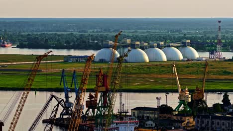 industrial port scene with cranes near river on a sunny day