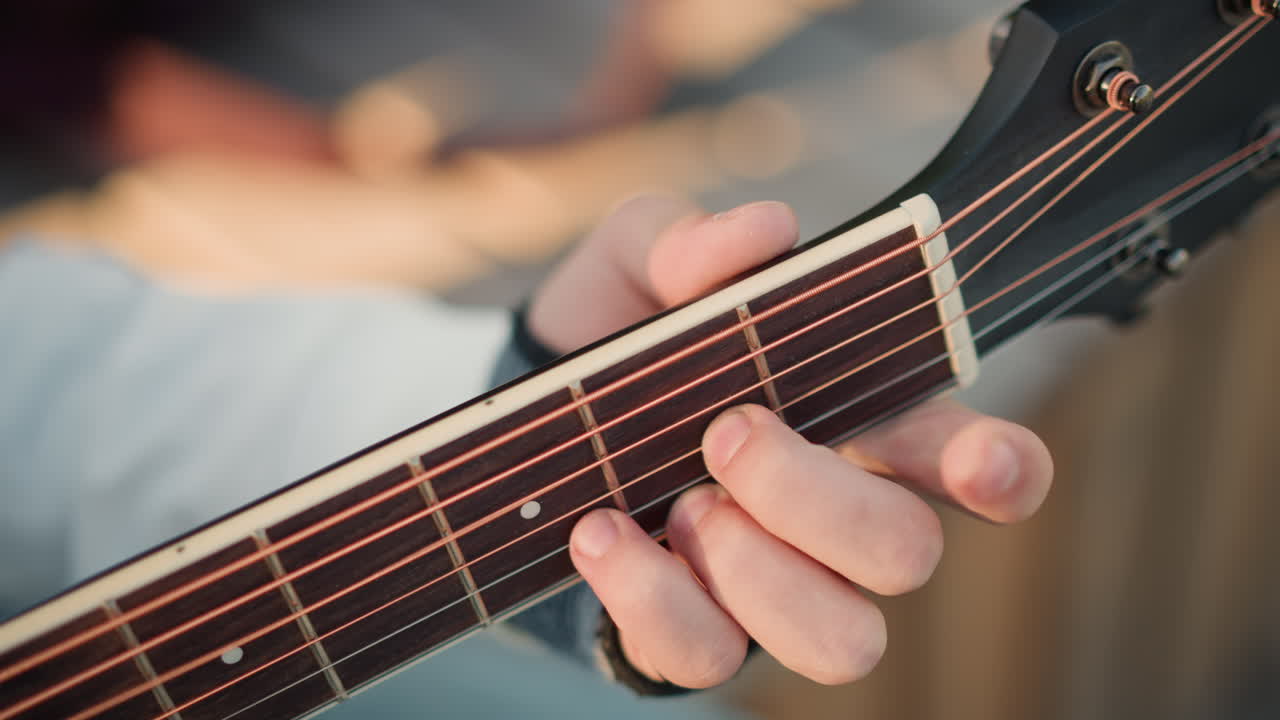 closeup hands on acoustic guitar fretboard showing unspecified person practicing fingerstyle technique, ring on finger, warm wood tones, detailed chord shapes, precise finger placement, tutorial mood