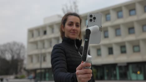 young woman manipulating a video stabilizer for mobile phone