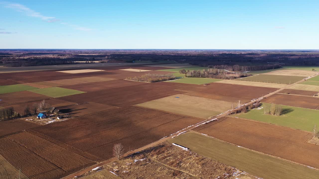 Aerial wide angle of brown fields at day with blue sky background
