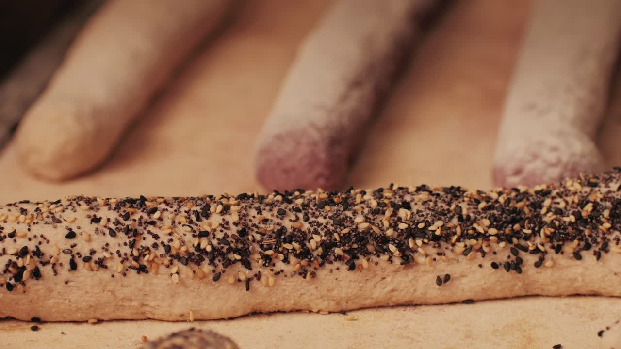 Bakery chef making fresh Artesian buns and baguettes using traditional recipe close-up. Young man kneading dough. Artisan bread is making by skill bakers using natural and high-quality ingredients. Food with health and flavour benefits. Bakery shop and market