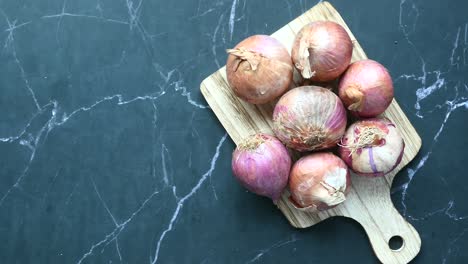 pile of onions on a wooden cutting board