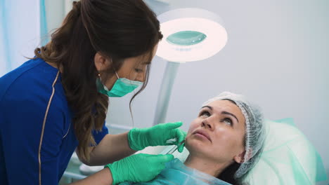 middle aged lady undergoes procedure of filler injection