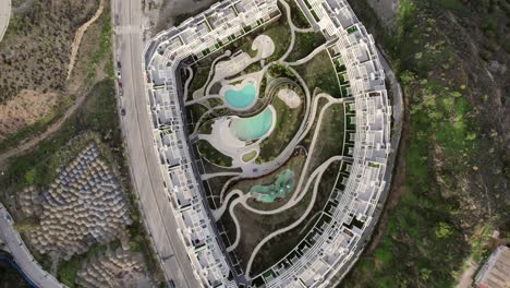 descending aerial view over new housing complex with landscaped pool area