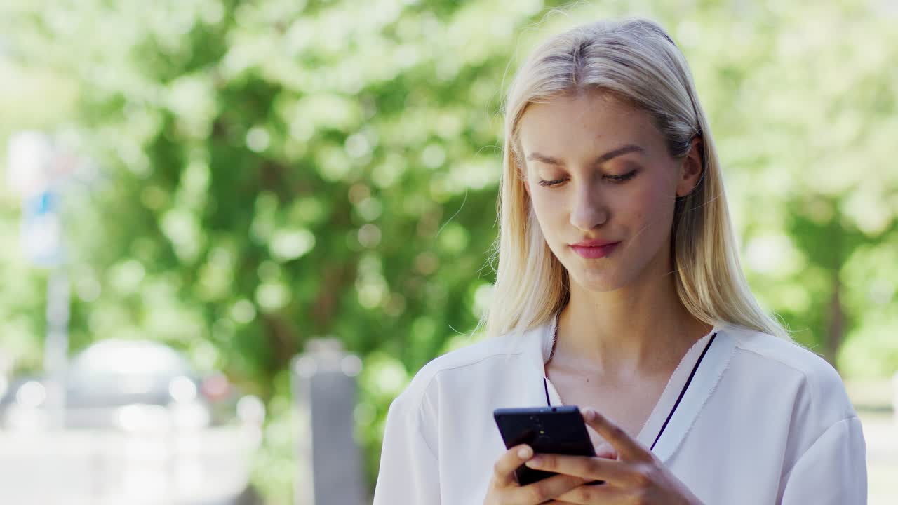 молодая женщина пользуется смартфоном на улице