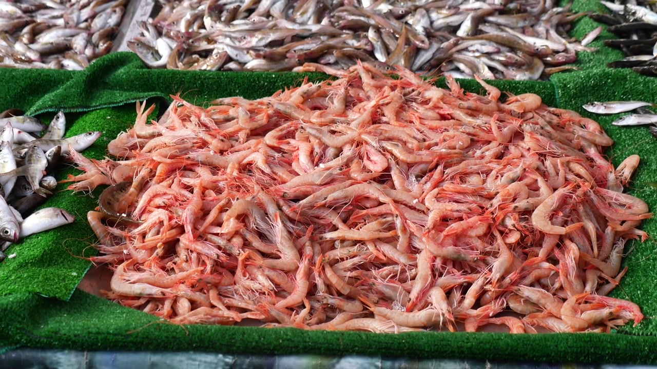 Gamberi e pesce freschi crudi esposti in un mercato locale