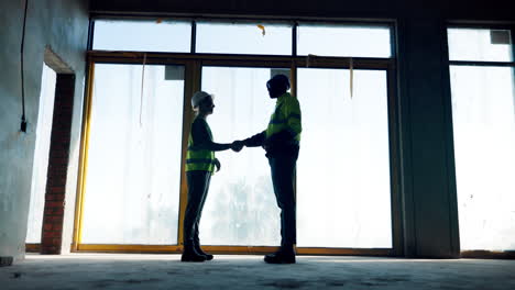 construction workers handshake on a building site