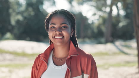 portrait of a smiling woman with braids in a park