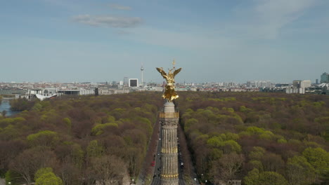 AERIAL:-Close-Up-Dolly-of-Berlin-Victory-Column-Golden-Statue-Victoria-in-Beautiful-Sunlight-and-Berlin,-Germany-Cityscape-Skyline-in-Background