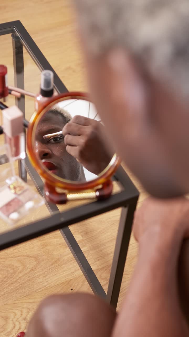 Person applying eye makeup in a mirror