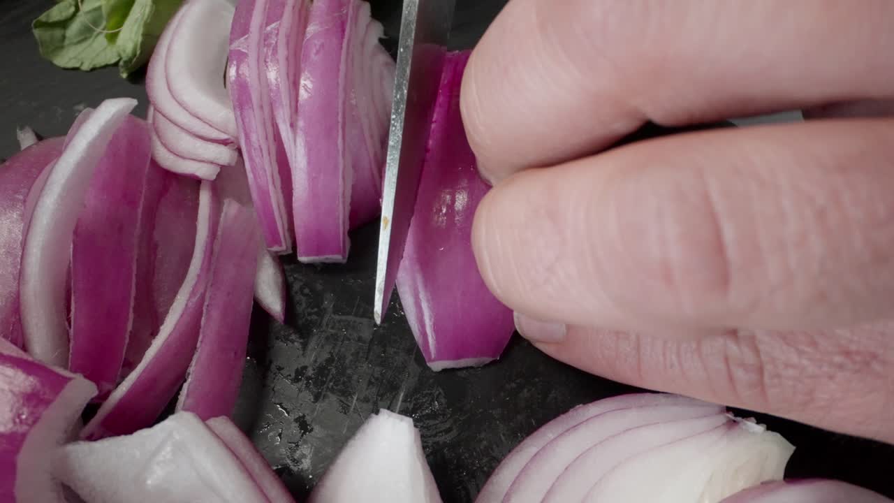 A chef is slicing a yellow pepper on a cutting board