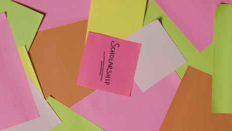 concepto educativo de notas adhesivas giratorias con beca escrita en la nota superior