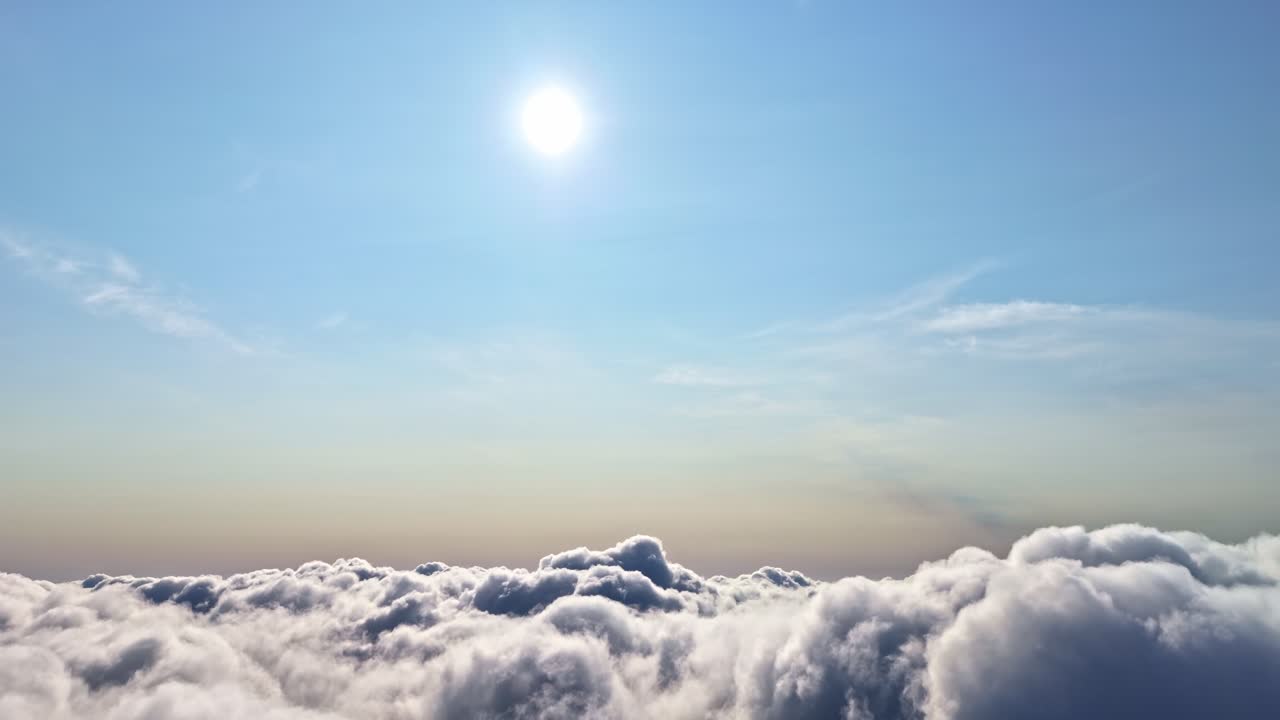 Spettacolare vista aerea che sorvola un vasto tappeto di nuvole sotto un brillante sole di mezzogiorno.