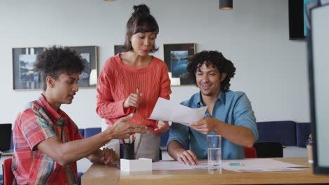 Happy-diverse-business-people-discussing-work-during-meeting-at-office