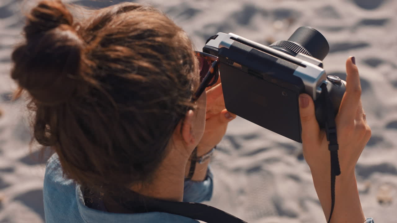 joven fotógrafa tomando fotos en la playa usando una cámara retro disfrutando del día de vacaciones de verano joven fotografiando la hermosa orilla del mar