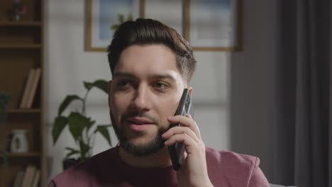 joven complacido en casa recibiendo una llamada telefónica que confirma la oferta de trabajo 3
