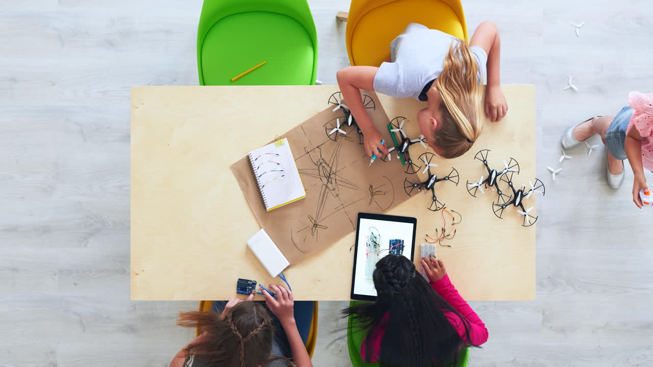 소녀들이 교실에서 드론을 만들고 있습니다.