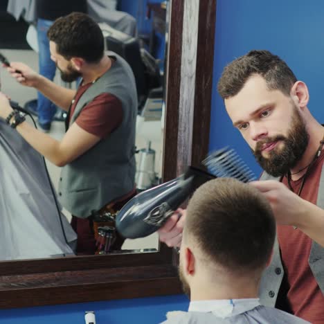 barber brushing and blow-drying hair for client