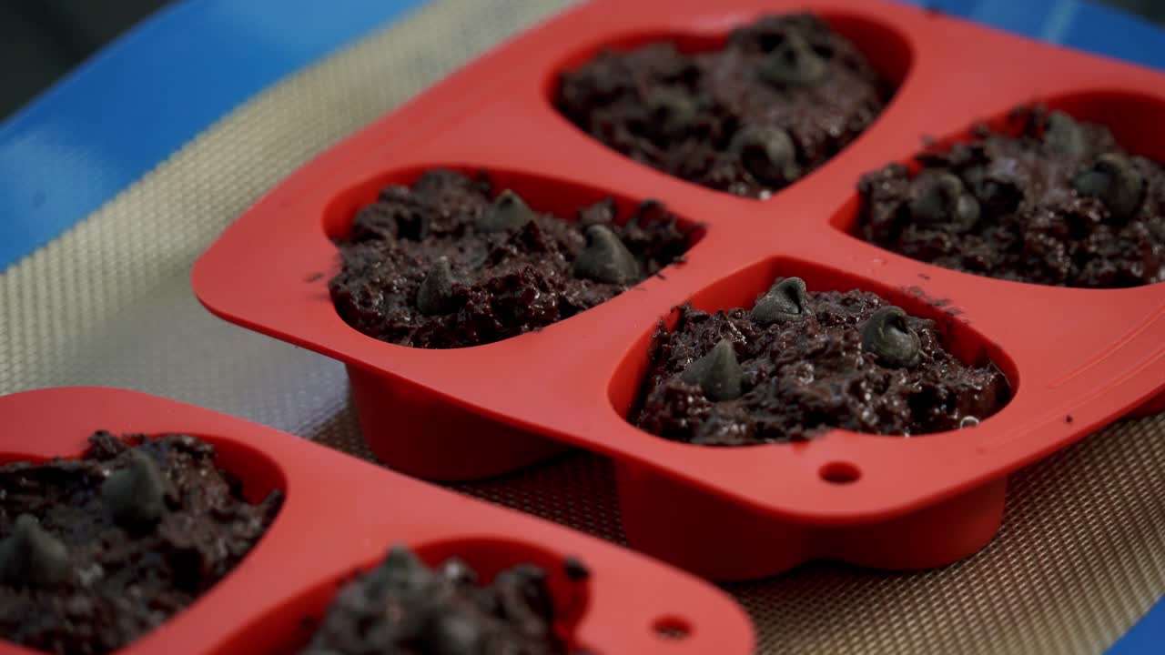 Primo piano di muffin al cioccolato e barbabietola in una teglia da forno, a forma di cuore per San Valentino