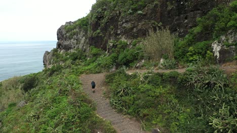 a single man is hiking up the trail on the side of the mountain in madeira