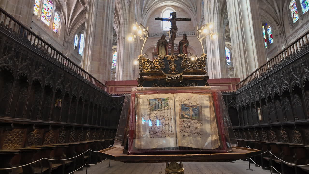 Interiér katedrály v Segovii s nasvícenou liturgickou knihou, zdobeným oltářem a symetrickou gotickou architekturou ve Španělsku.