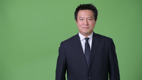 녹색 배경에 성숙한 일본 사업가