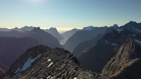 vista aérea volando sobre un pico rocoso en el épico desierto montañoso de los alpes del sur en nueva zelanda