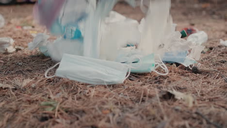 medical masks and plastic lies on the ground in the forest 1