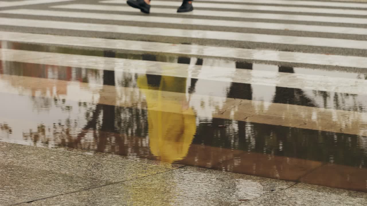 Business man tourist person with umbrella and raincoat on rainy european city street, lights reflecting, walking in Barcelona or Amsterdam during the rain